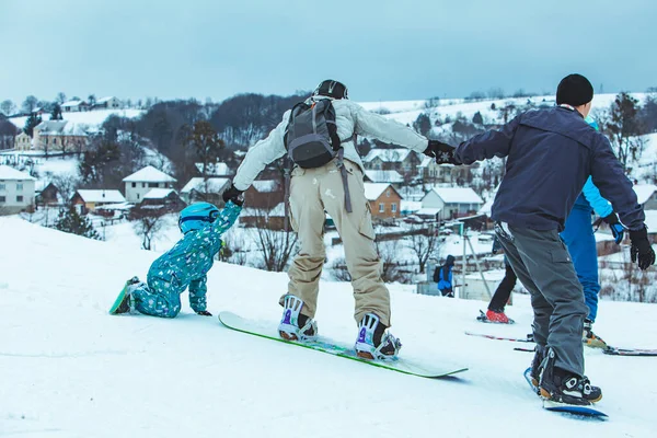 Anne küçük kıza snowboard yapmayı öğretiyor. — Stok fotoğraf