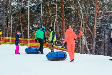 Lviv, Ukrayna - 7 Ocak 2019: Aile gezisi kar tübü ile kar tepesinde