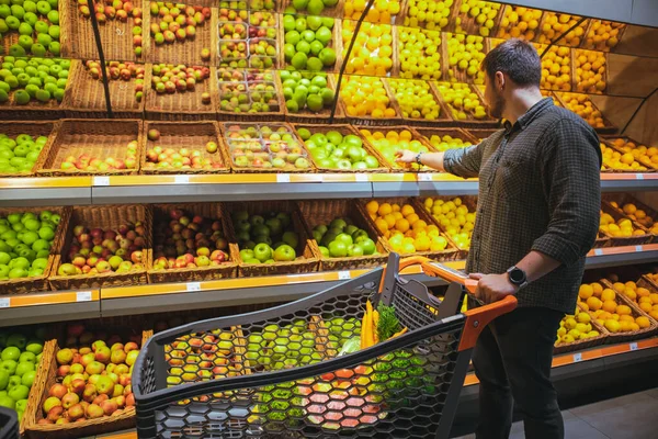 Człowiek w sklepie spożywczym zrobić zakupy kupując owoce — Zdjęcie stockowe