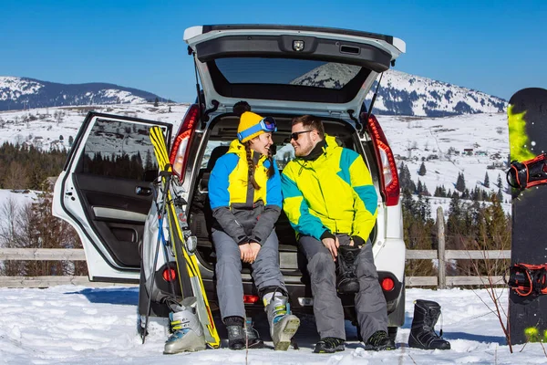 Kadın ve erkek arazi aracı yakınlarında kayak malzemesi giyiyorlar. — Stok fotoğraf
