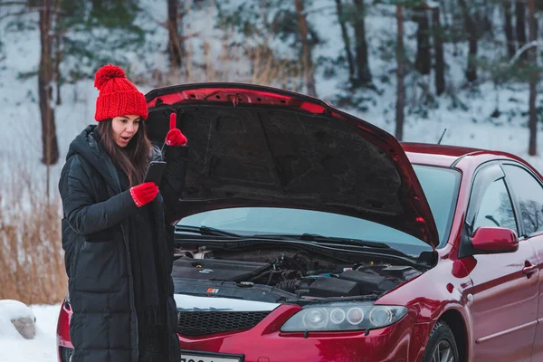 Mulher pedindo ajuda com carro quebrado na estrada de inverno — Fotografia de Stock