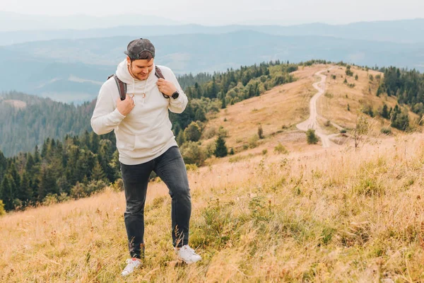 Man med ryggsäck vandring genom höst berg — Stockfoto