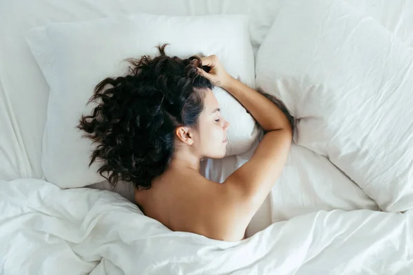 Woman sleeping in bed bright light on face — Stockfoto