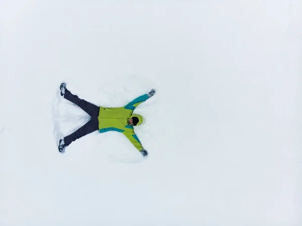 Visão aérea do homem fazendo anjo da neve — Fotografia de Stock