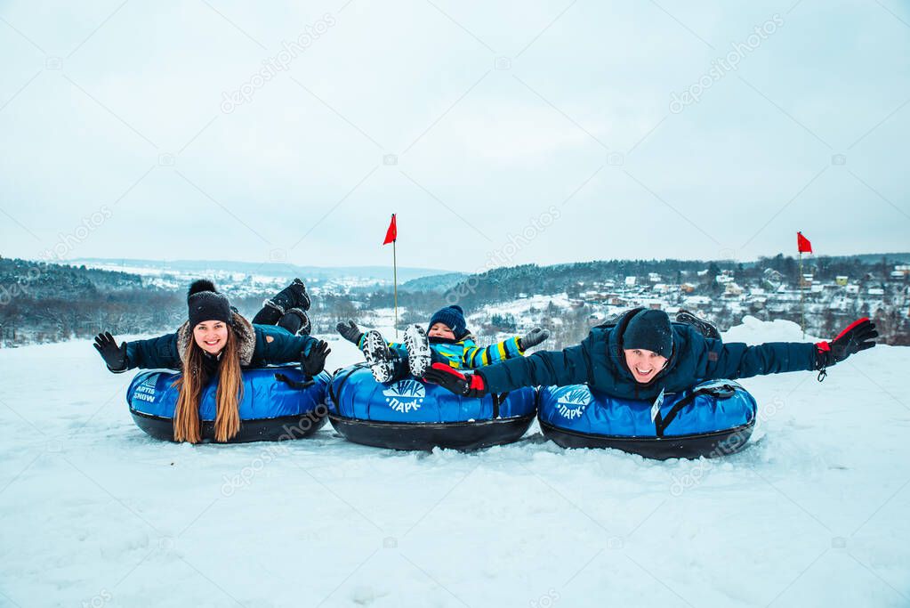 young family posing with snow tubes. winter time
