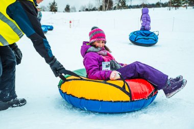 Lviv, Ukrayna - 7 Ocak 2019: Aile gezisi kar tübü ile kar tepesinde