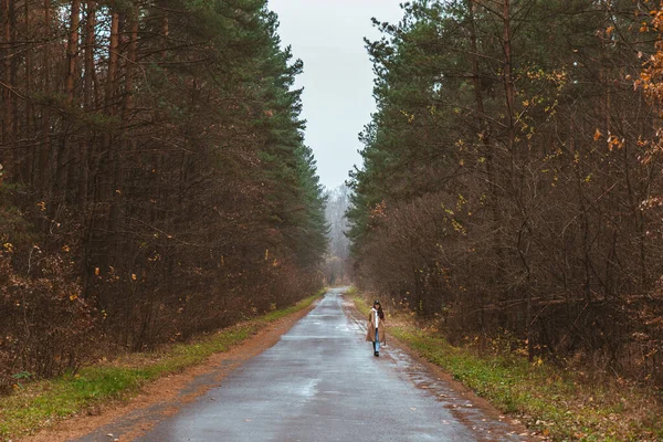 Femeia mergând pe drumul gol de toamnă — Fotografie, imagine de stoc