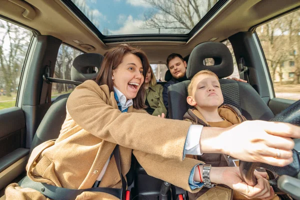 Araba seyahat eğlenceli kavramı. Küçük çocuk yetişkinlerle araba sürüyor. kendine güvenen sürücü — Stok fotoğraf