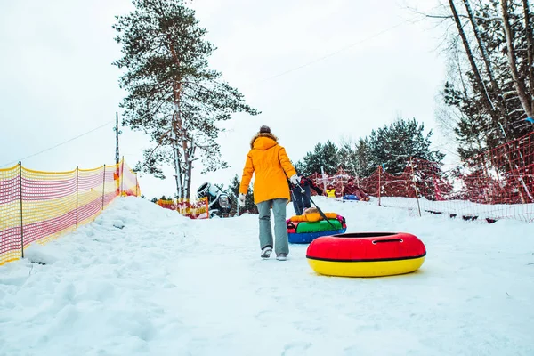 Люди карабкаются на холм ради снежных трубок — стоковое фото