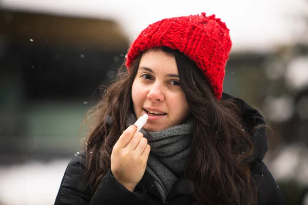 woman using cream at cold winter weather. skin protection