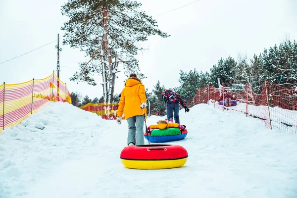 Pessoas subindo por colina para tubos de neve — Fotografia de Stock