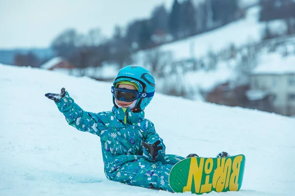 LVIV, UCRANIA - 12 de enero de 2019: niña aprendiendo snowboard. se caen — Foto de Stock