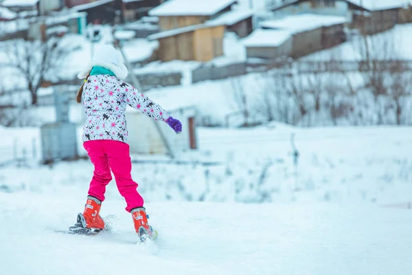 Lviv, Ukrayna - 12 Ocak 2019: Pembe pantolonlu kız karlı tepede kayak yapıyor. — Stok fotoğraf