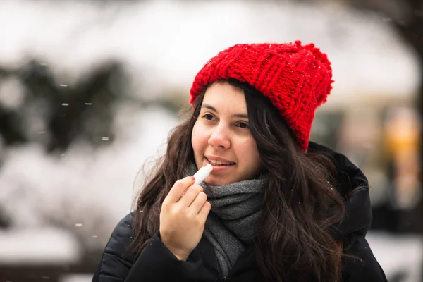 woman using cream at cold winter weather. skin protection