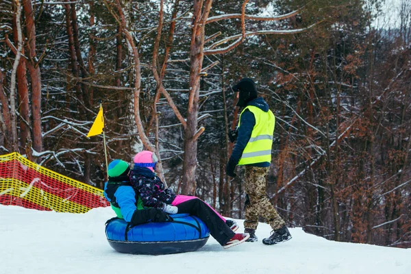 Attività invernali divertenti. giro giù in collina su tubi di neve — Foto Stock