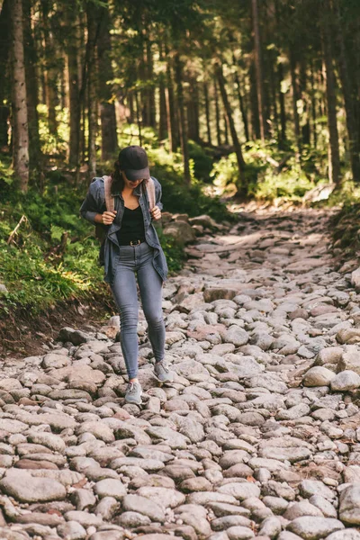 Femme avec sac à dos randonnée en forêt par sentier en pierre — Photo