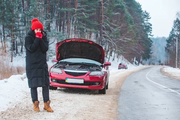 Mulher olhando motor quebrado carro no lado da estrada de inverno — Fotografia de Stock