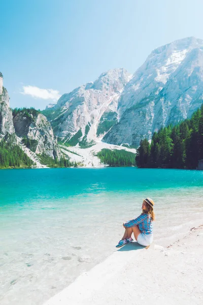 Mujer sentada en la playa del lago de montaña temporada de verano — Foto de Stock