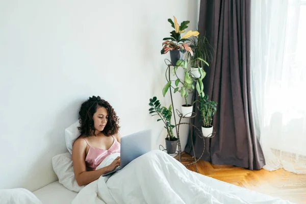 Kvinna med laptop i sängen frilansare — Stockfoto