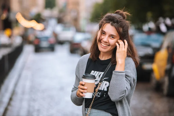 Lviv, Ucrânia - Julho 17, 2019: jovem mulher bonita na rua da cidade beber café de copo descartável — Fotografia de Stock