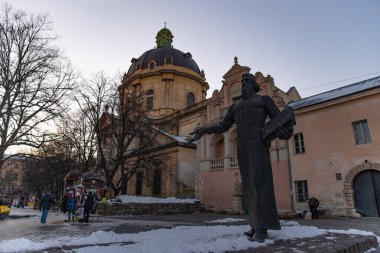Lviv, Ukrayna - 22 Mart 2018: Arka plandaki eski kilise meydanındaki heykel manzarası
