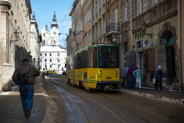Κίτρινο δημόσιο τραμ στο αστικό δρόμο της πόλης το χειμώνα — Φωτογραφία Αρχείου