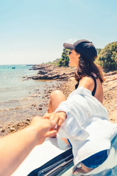 Frau sitzt auf Motorhaube des Autos und ruht sich am Strand aus — Stockfoto