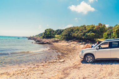 yaz plaj tatil konseptinde oto kaput üzerinde oturan kadın