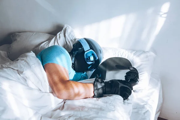 Человек в постели со сноубордом лыжные гуглы и шлем — стоковое фото