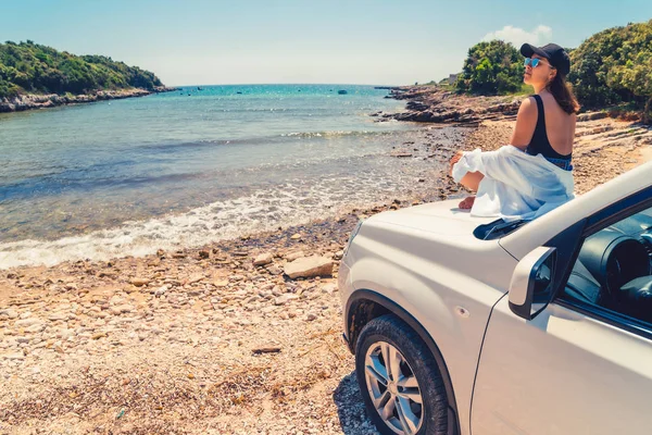 妇女躺在汽车引擎盖与海夏海滩的景色 — 图库照片