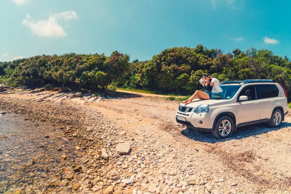 Frau sitzt bei Sommerurlaub am Strand auf Motorhaube — Stockfoto