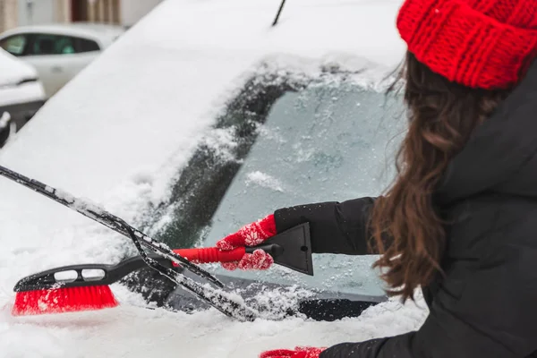 Kvinna ren bil med borste efter snö — Stockfoto