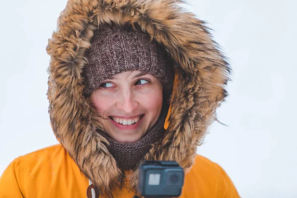 Portré csinos nő télen sárga kabát szőrme motorháztető gazdaság akció kamera — Stock Fotó