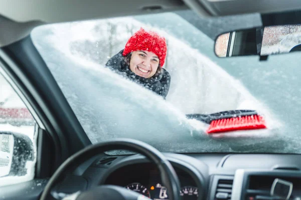 Ung vacker kvinna rengöring bil efter snöstorm — Stockfoto