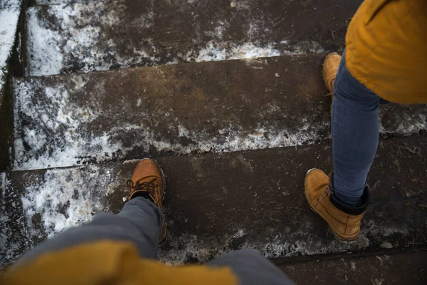 Jambes d'homme et de femme se réveillant par des escaliers glissants glacés — Photo