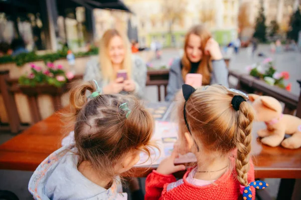 Little girl sitting in cafe choosing food from menu — Stock Photo, Image