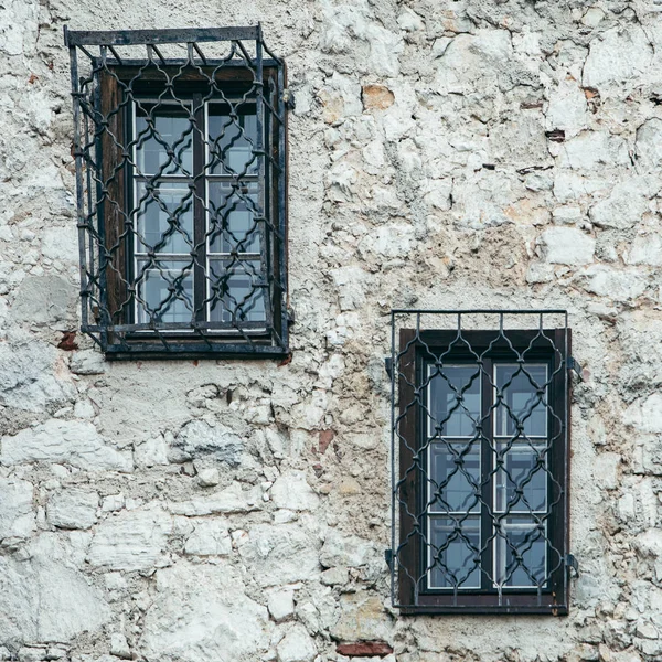 Windows with metal shutters at gray stone building wall — Stock Photo, Image