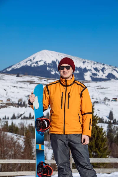 Homem de óculos escuros segurando snowboard — Fotografia de Stock