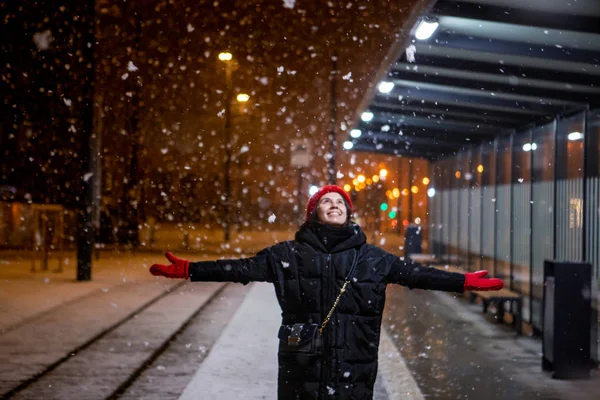 Mujer mirando la nieve de pie en la estación de tranvía noche de invierno — Foto de Stock