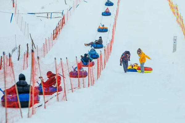 Lviv, ukraine - 7. januar 2019: linie für snow tubing. Menschen auf Hügel ziehen. — Stockfoto