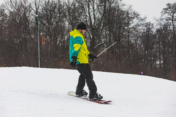 Junger erwachsener Mann beim Snowboarden und Selfie vor Action-Kamera — Stockfoto