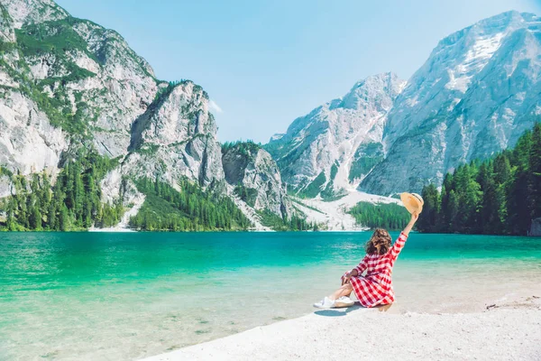 Vrouw zittend op het strand van bergmeer zomerseizoen — Stockfoto