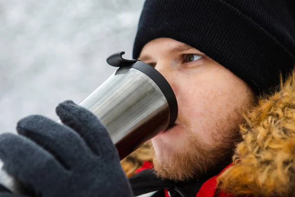 Young adult man drinking coffee from refillable mug outdoors — 스톡 사진