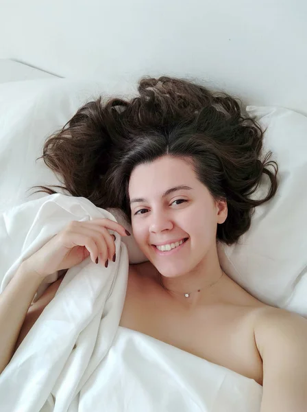 युवा सुंदर महिला बिस्तर में सेल्फी तस्वीर छवि ले रही — स्टॉक फ़ोटो, इमेज
