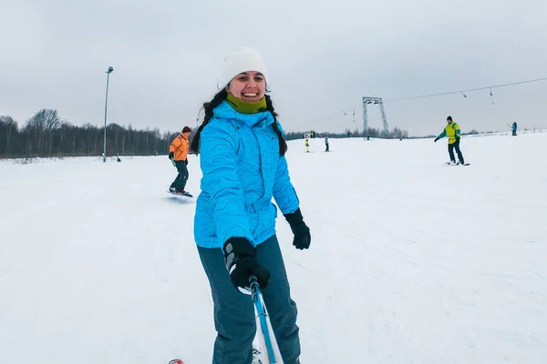 Mulher tomando selfie enquanto esquiando para baixo pela colina nevada — Fotografia de Stock