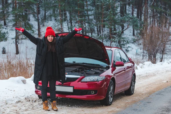 Сердитая женщина на зимнем обочине рядом со сломанной машиной — стоковое фото
