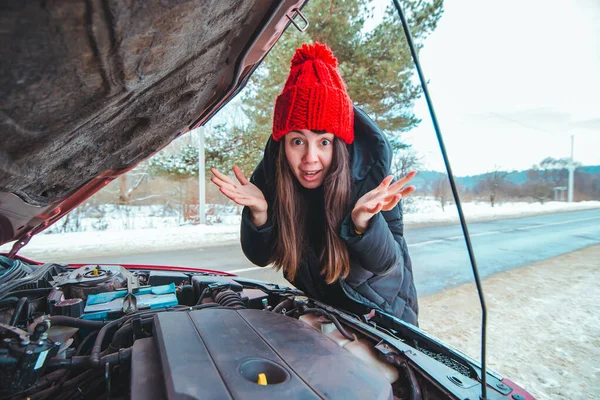 Женщина смотрит на автомобильный двигатель дорожной помощи — стоковое фото