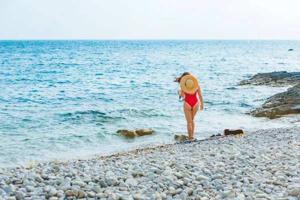 Jong mooi vrouw in stro hoed op zee strand — Stockfoto