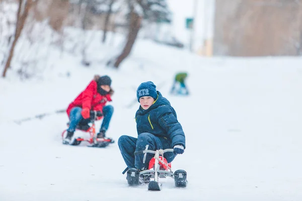 Lviv, Ucrania - 5 de enero de 2019: los niños que se deslizan de la colina nevada —  Fotos de Stock