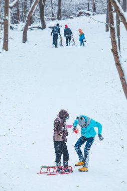 Lviv, Ukraine - January 5, 2019: kids sliding from snowed hill